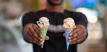 Some one holding ice cream cones